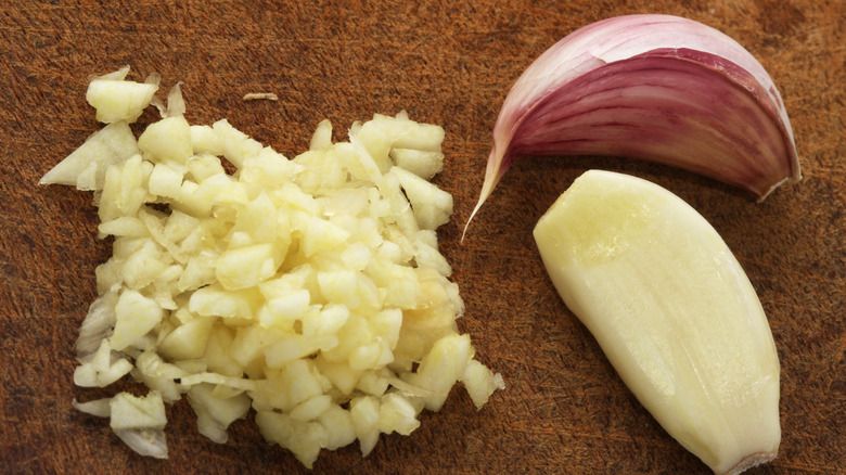 Peeled and unpeeled cloves of garlic along with some finely chopped garlic