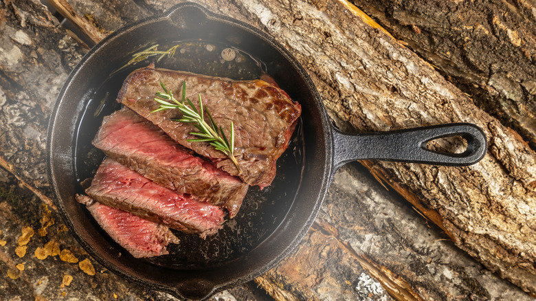 Steaming, rare steak in cast iron skillet