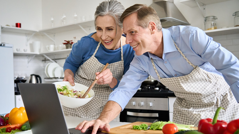 couple cooking while on computer