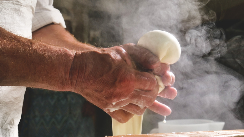 person making mozzarella cheese