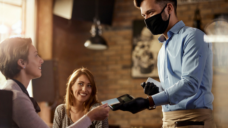 Waiter handing customers their bill