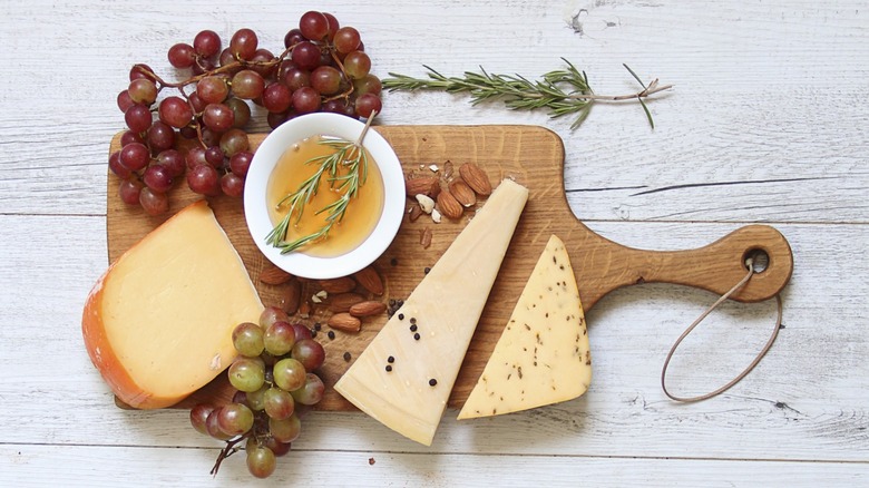 cheese board with almonds, grapes, and olive oil