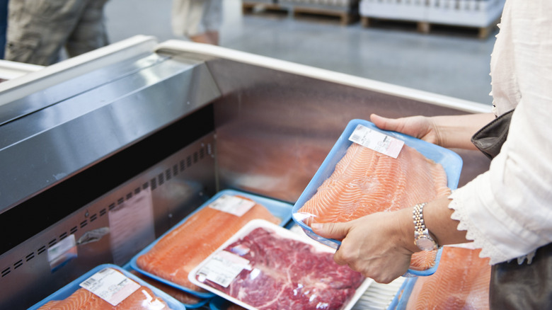 woman holding tray of salmon