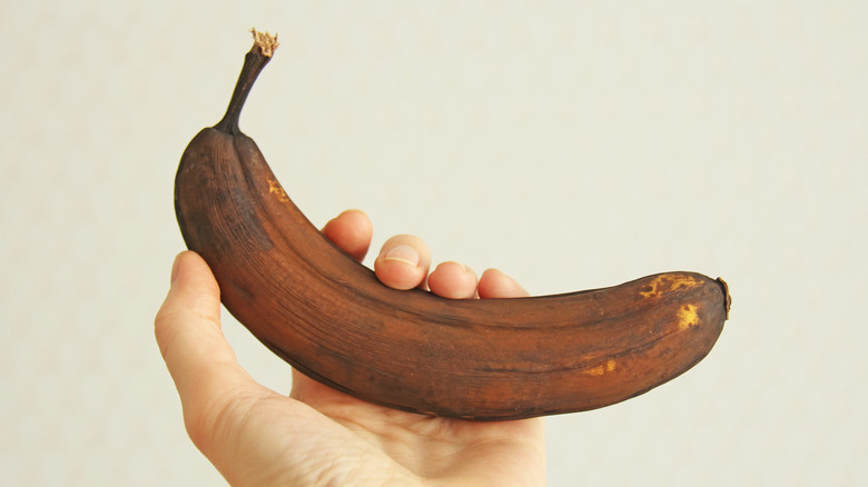 Overripe banana held by hand