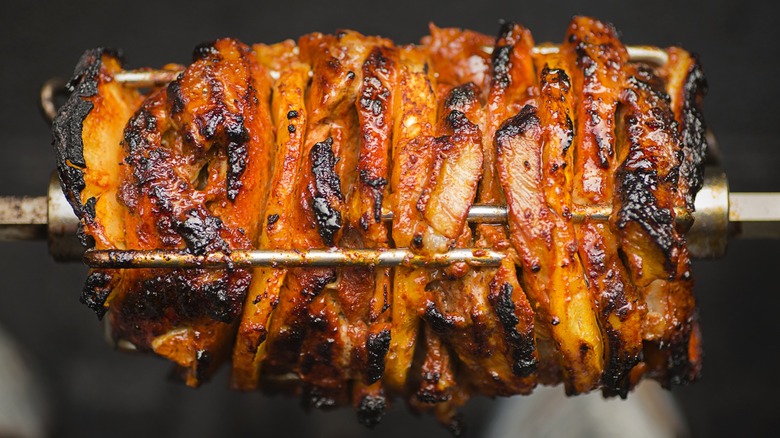 Close-up of al pastor pork and pineapple on a rotisserie spit