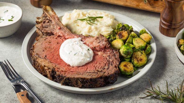 Homemade prime rib with horseradish cream sauce, mashed potatoes, and Brussels sprouts