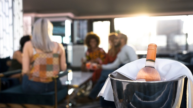 gathering with a bottle of rose in an ice bucket