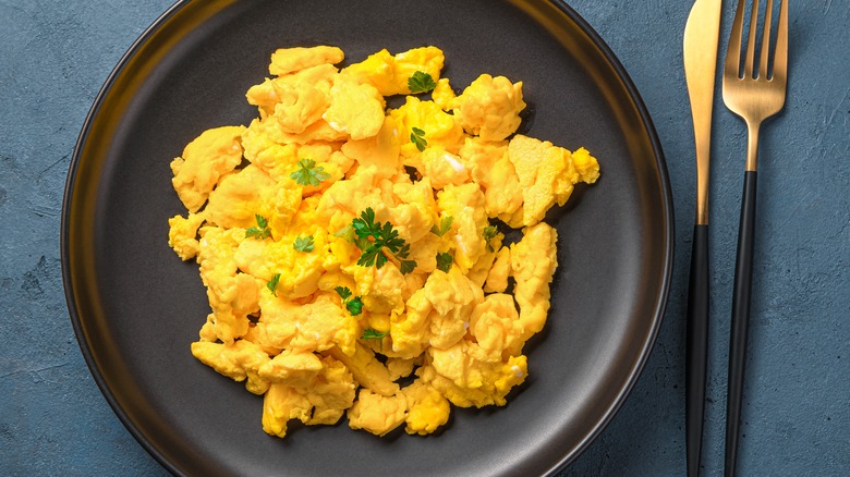 Scrambled eggs on black plate 