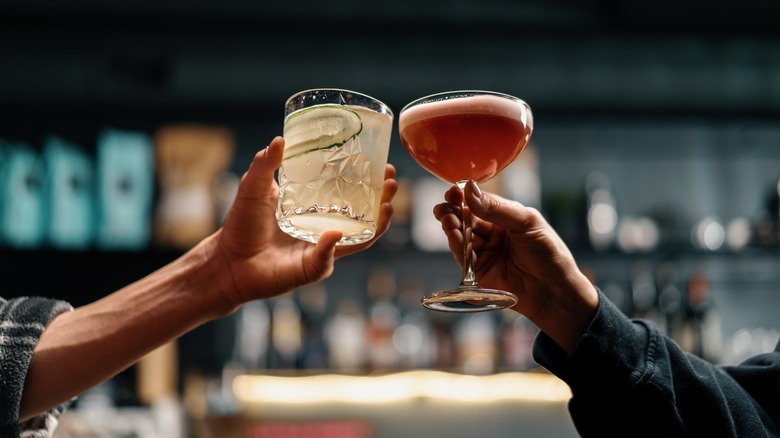 two people sharing cocktails