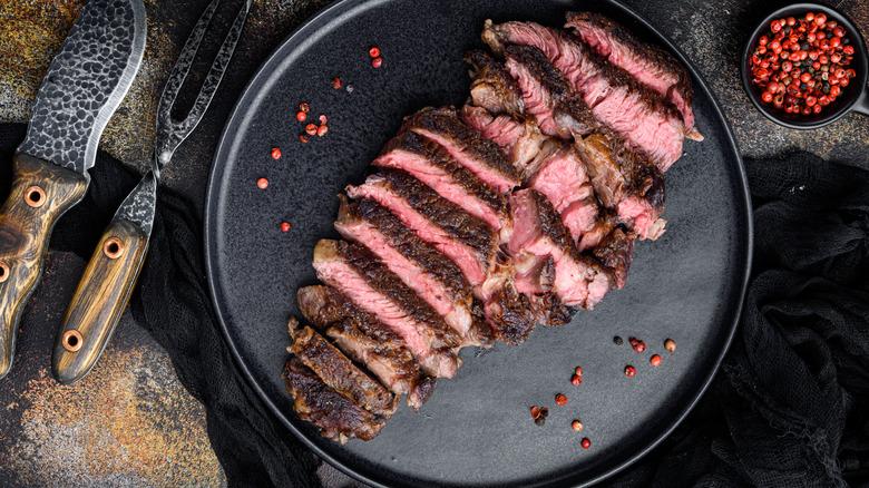 Sliced steak on black plate 