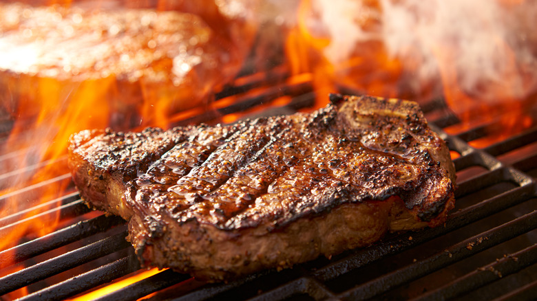 Steak on flaming grill