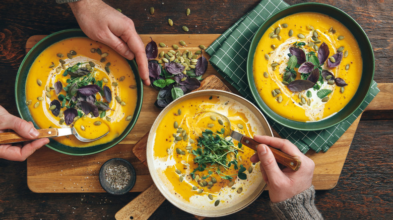 Bowls of soup being spooned and eaten