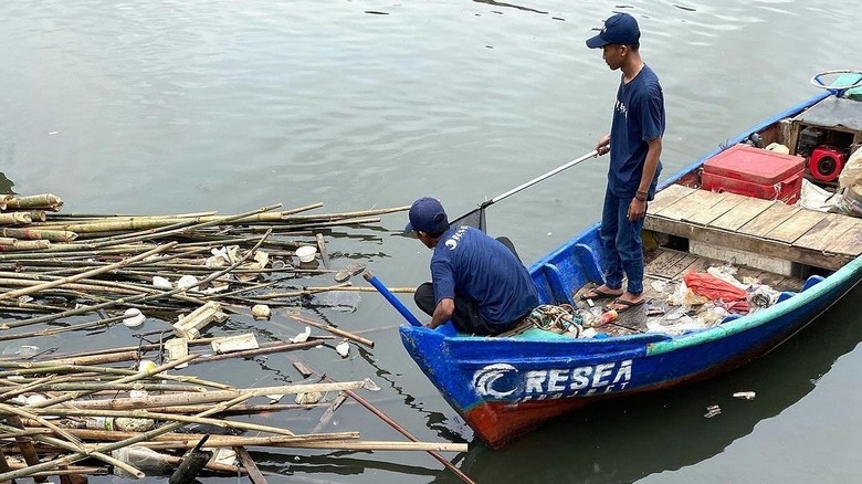 Men on boat cleaning river