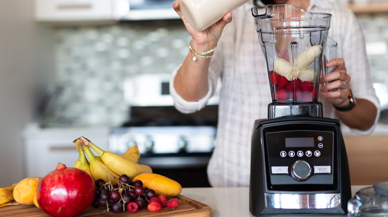 Black food processor on kitchen counter with fruit