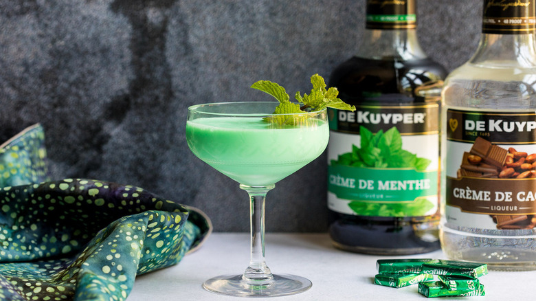 Retro Grasshopper cocktail next to ingredients 