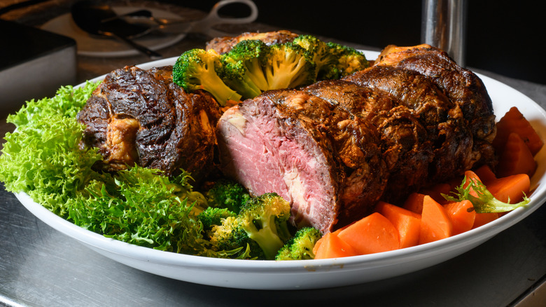 platter of roast beef surrounded by vegetables