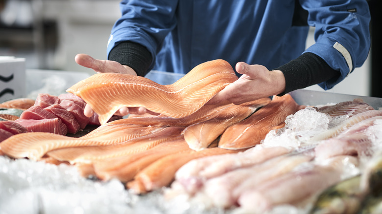 Person selecting raw fish