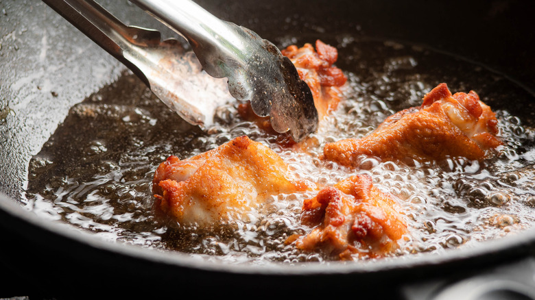 Frying chicken in stovetop pan 