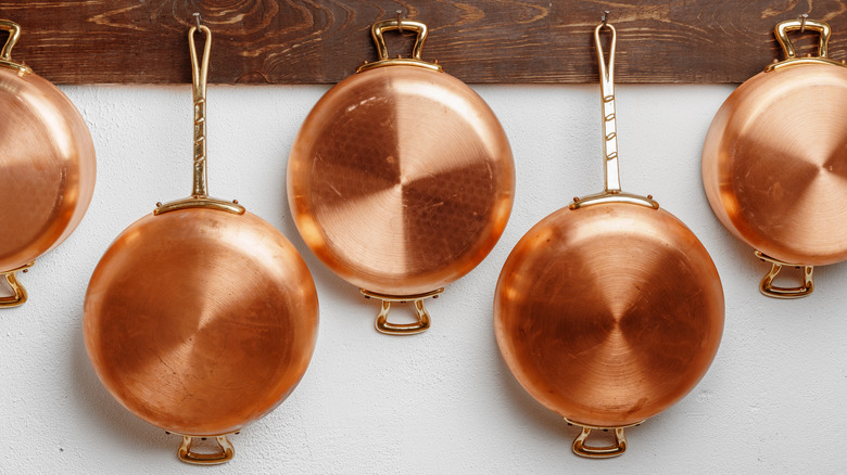 Copper cookware hanging on hooks