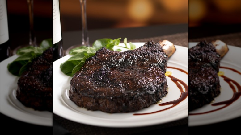 grilled bone-in ribeye on white plate