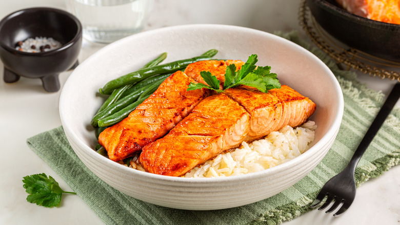 bowl of cooked salmon with green beans and rice