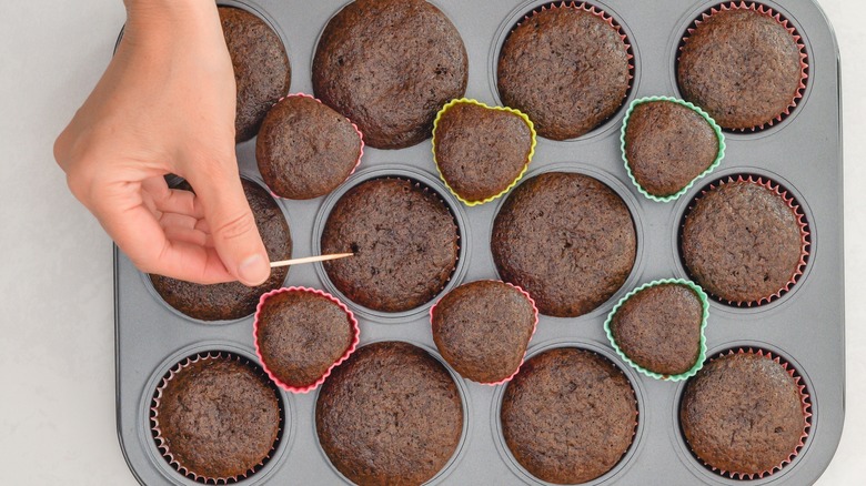 Doing toothpick test on chocolate cupcakes