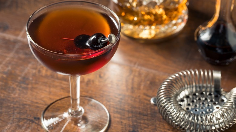 A Manhattan served with two Amarena cherries in a martini glass