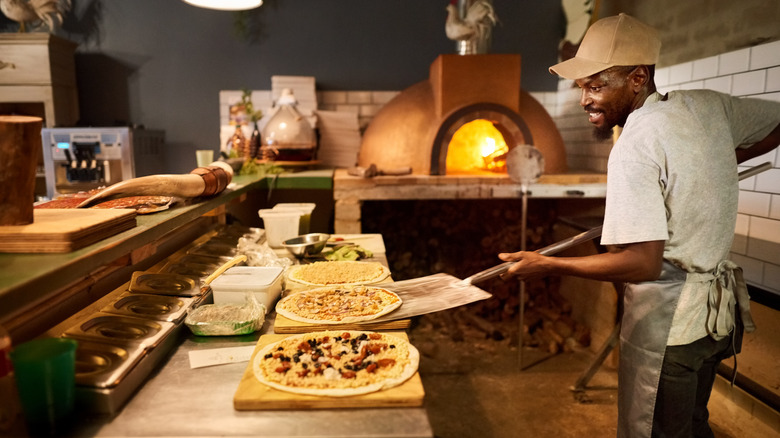 chef picking up pizza with peel