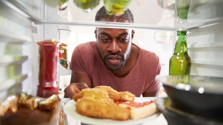 a man gives into his keto flu feelings by eating carbs