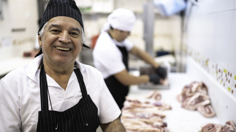 Smiling butcher at counter