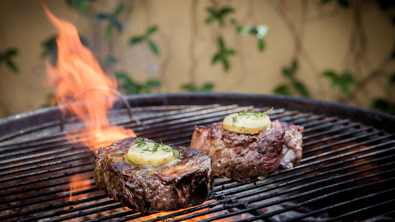 steaks on barbecue with flames