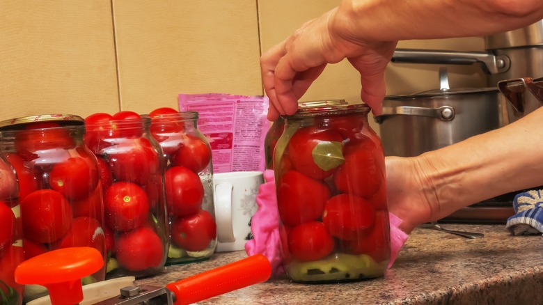 Hands wiping canned jars of food