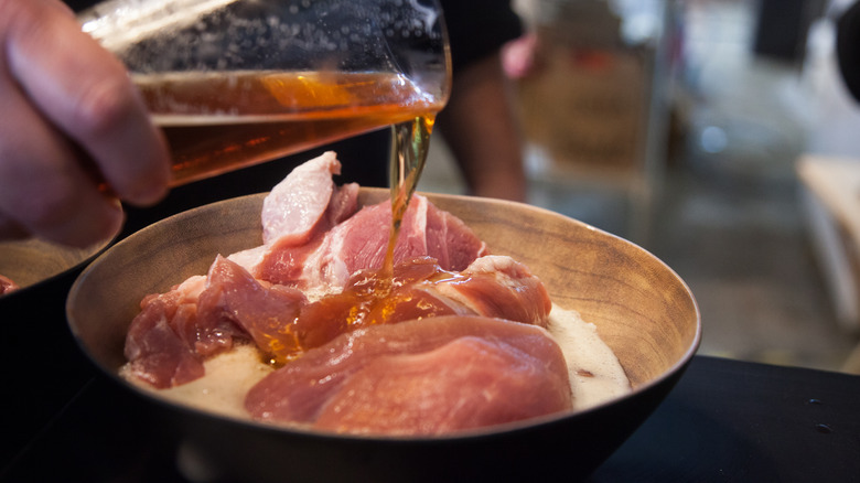 Home cook marinating meat with craft beer