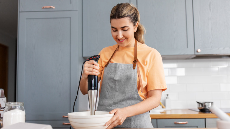 a woman blends soup