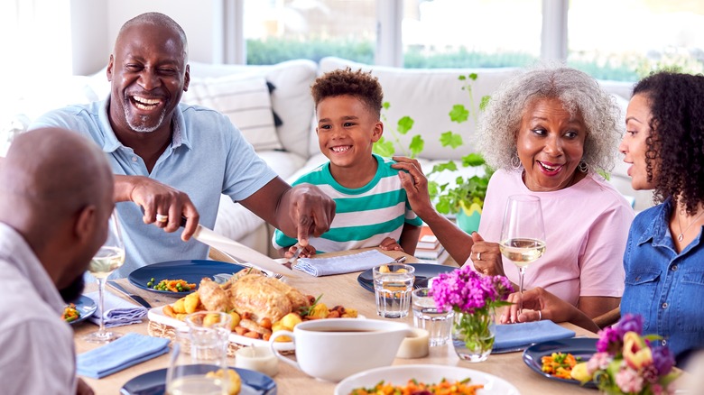 Family enjoying roasted chicken and vegetables meal