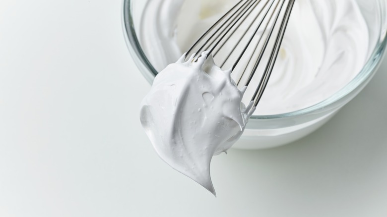 a bowl of whipped cream with a whisk on top