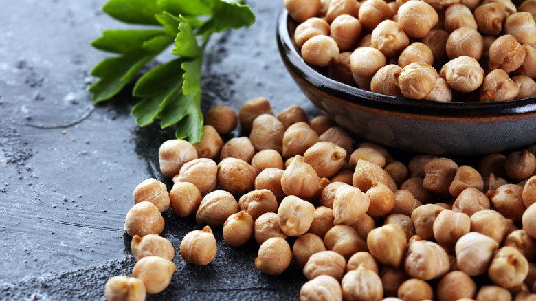 raw chickpeas in bowl and on table