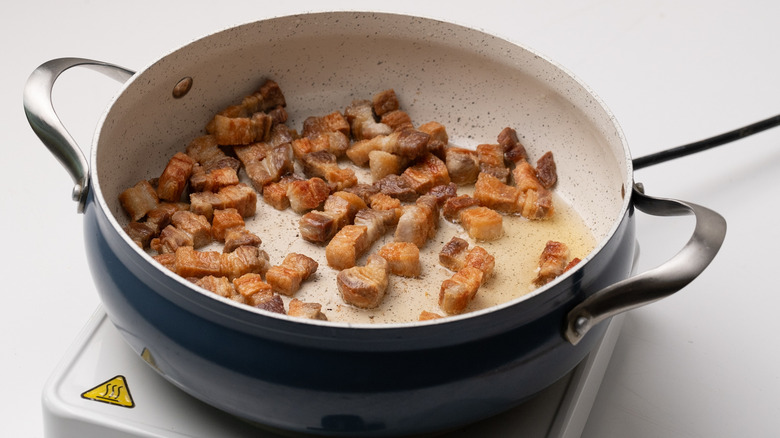 Pork belly frying in pan 