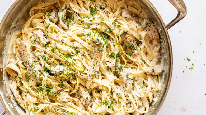 chicken alfredo fetuccini in a sauce pan