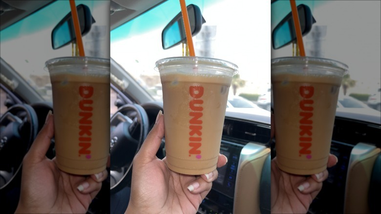 hand holding a Dunkin iced coffee