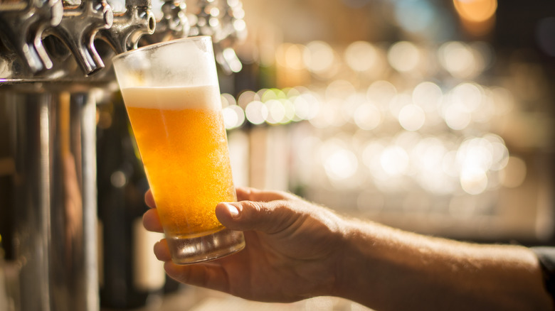 Hand pouring beer from a tap