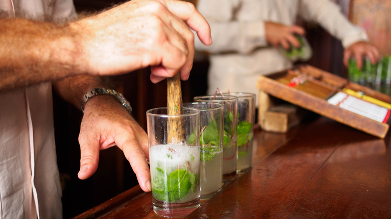 muddling mint in glasses