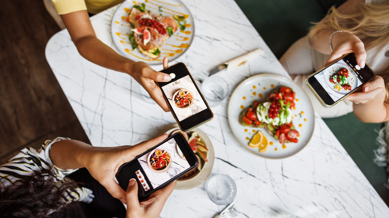 People photographing their restaurant meals