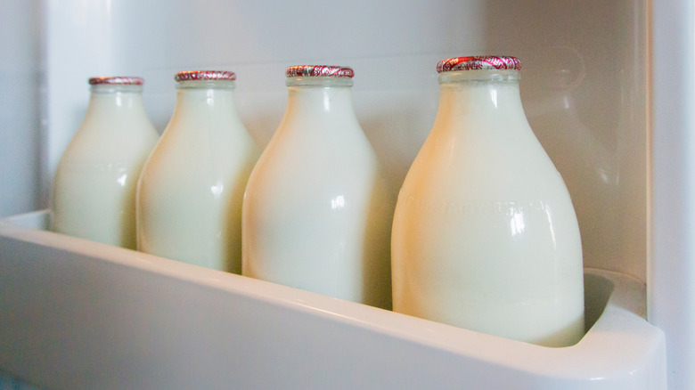 bottles of milk in fridge door shelf