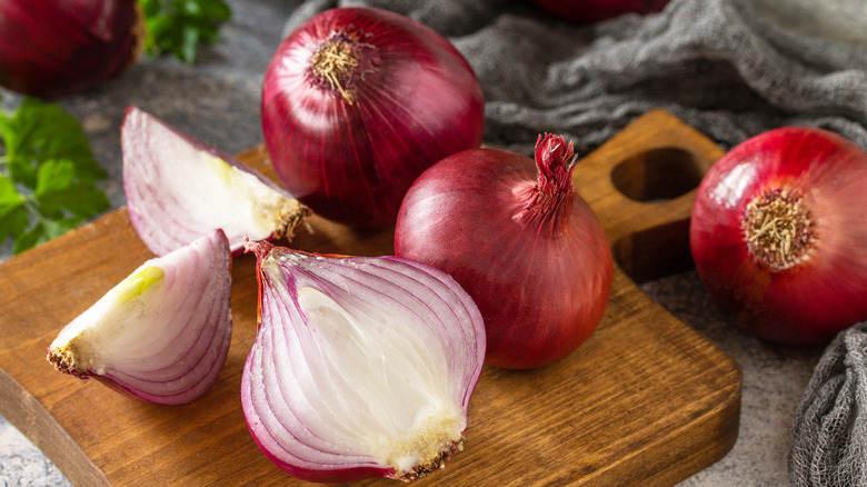 Quartered red onions on a cutting board