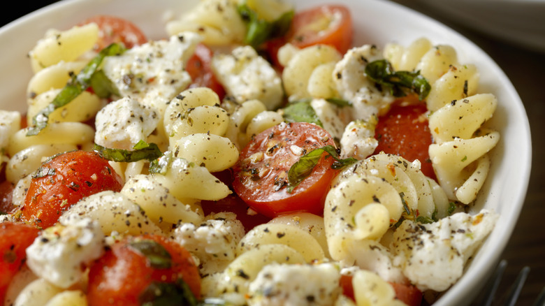 Closeup of fusilli pasta salad with tomatoes and feta