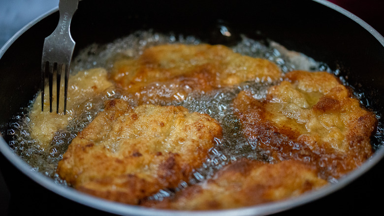 A close-up of someone deep-frying food.