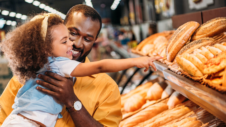 parent and child looking at bread at the supermarket