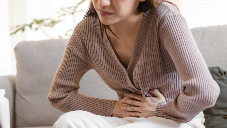 Woman holding stomach in pain