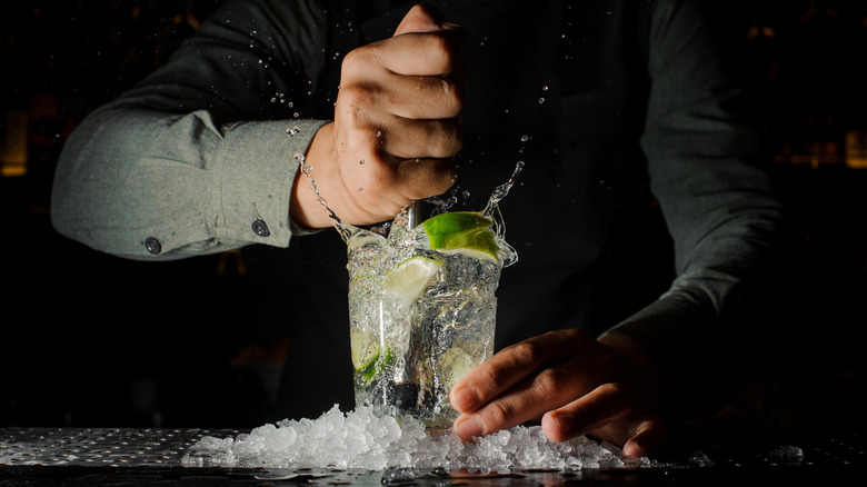 bartender mixing drink with citrus